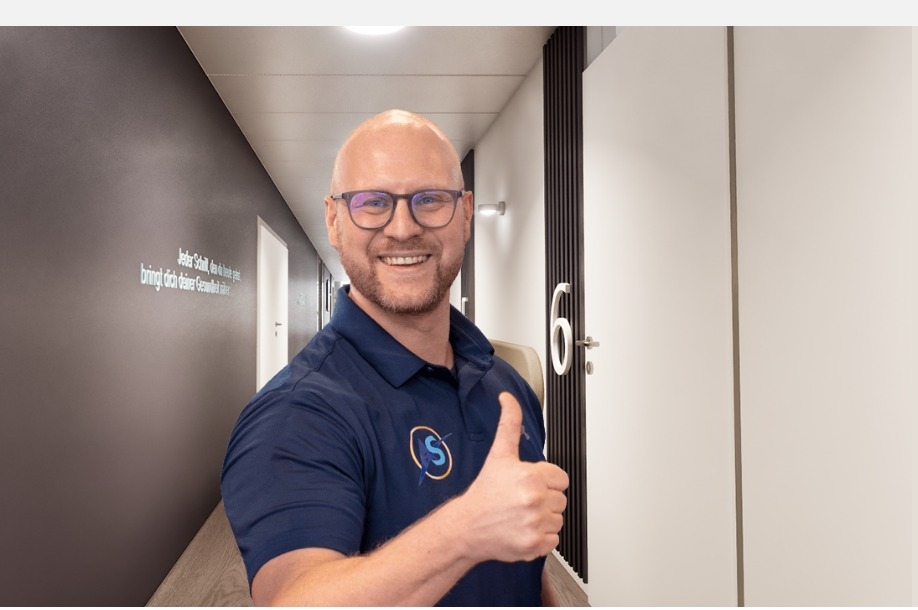 Therapeut von AS Physio begrüßt am Praxiseingang